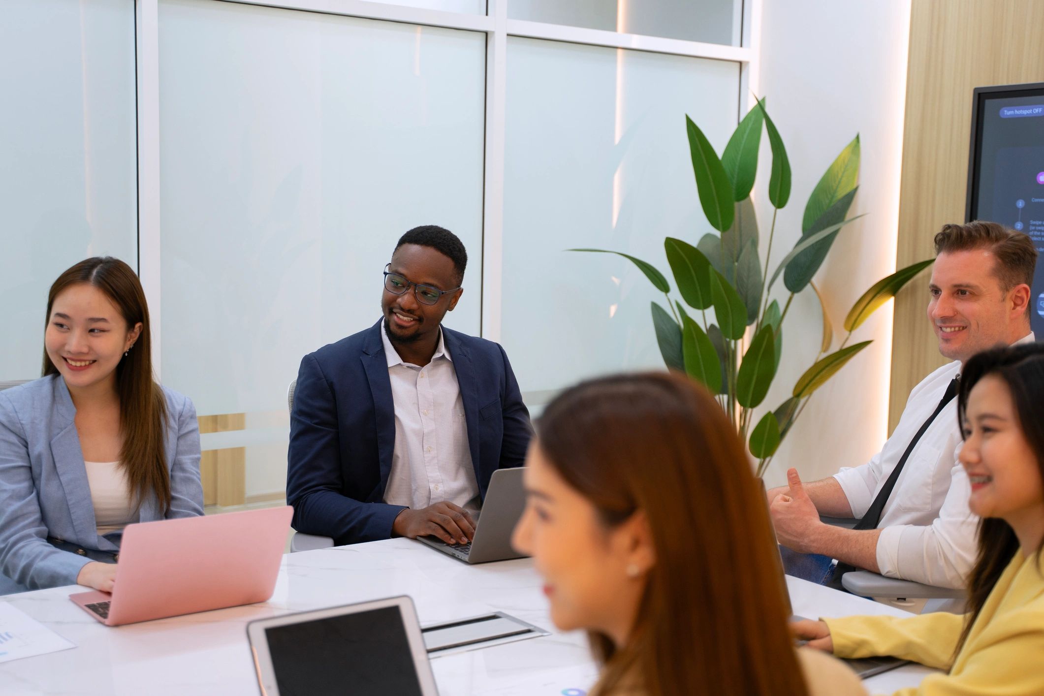 Professionals meeting around a laptop to discuss a financial services initiative